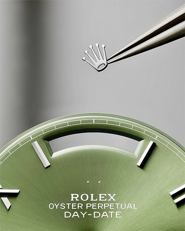 Creative ad: Tweezers placing a crown emblem above an olive-green watch dial