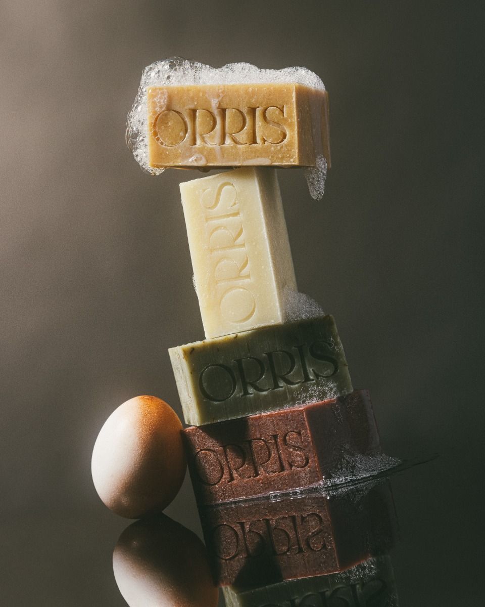 Instagram post: Balanced stack of four coloured soap bars with foam beside an egg
