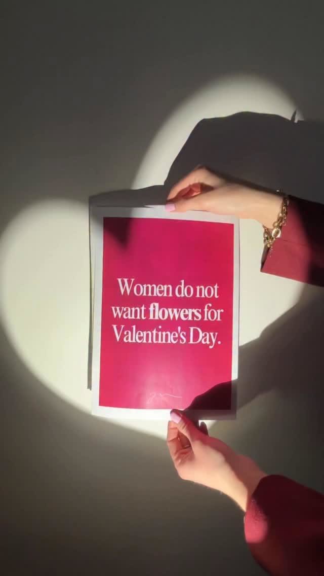 Hands holding a magenta sign in a heart-shaped spotlight