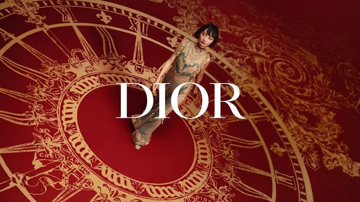 New Year creative ad: Model in embellished gown walking across a giant red-and-gold clock-face floor