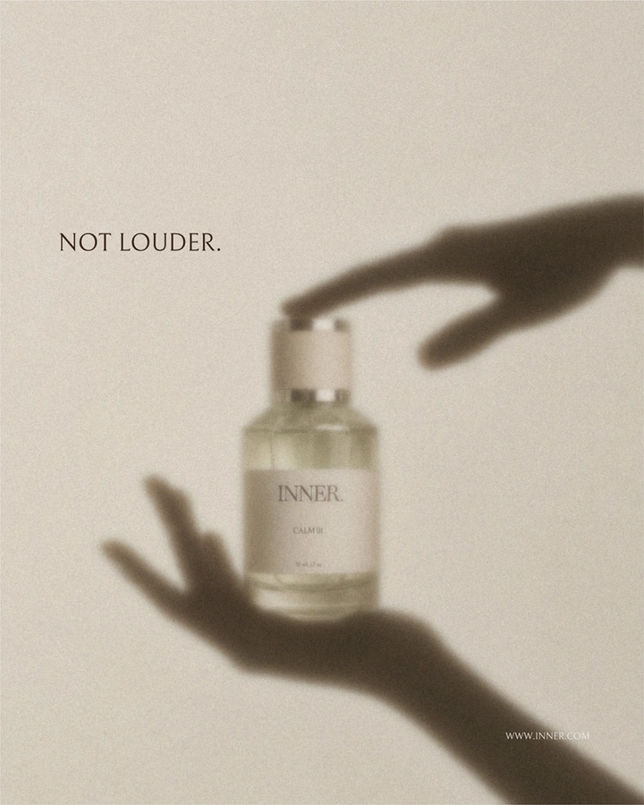 Wellness & Ayurveda creative ad: Perfume bottle framed by shadow silhouettes of hands
