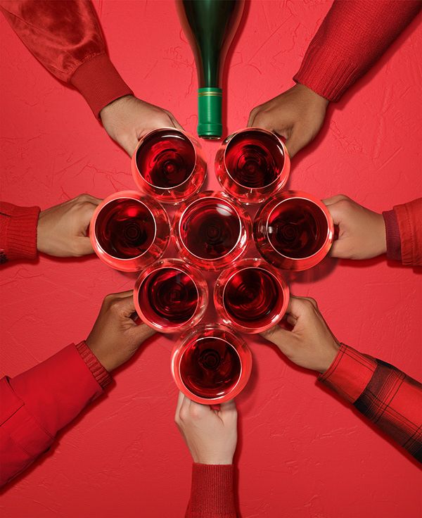 Christmas Instagram post: Top-down hands holding red wine glasses arranged in a festive cluster