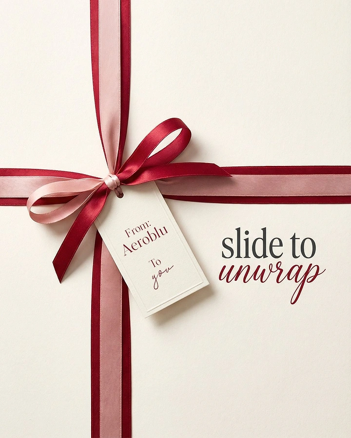 Valentine's Day creative ad: Top-down cream gift box tied with a two-tone satin ribbon bow and tag