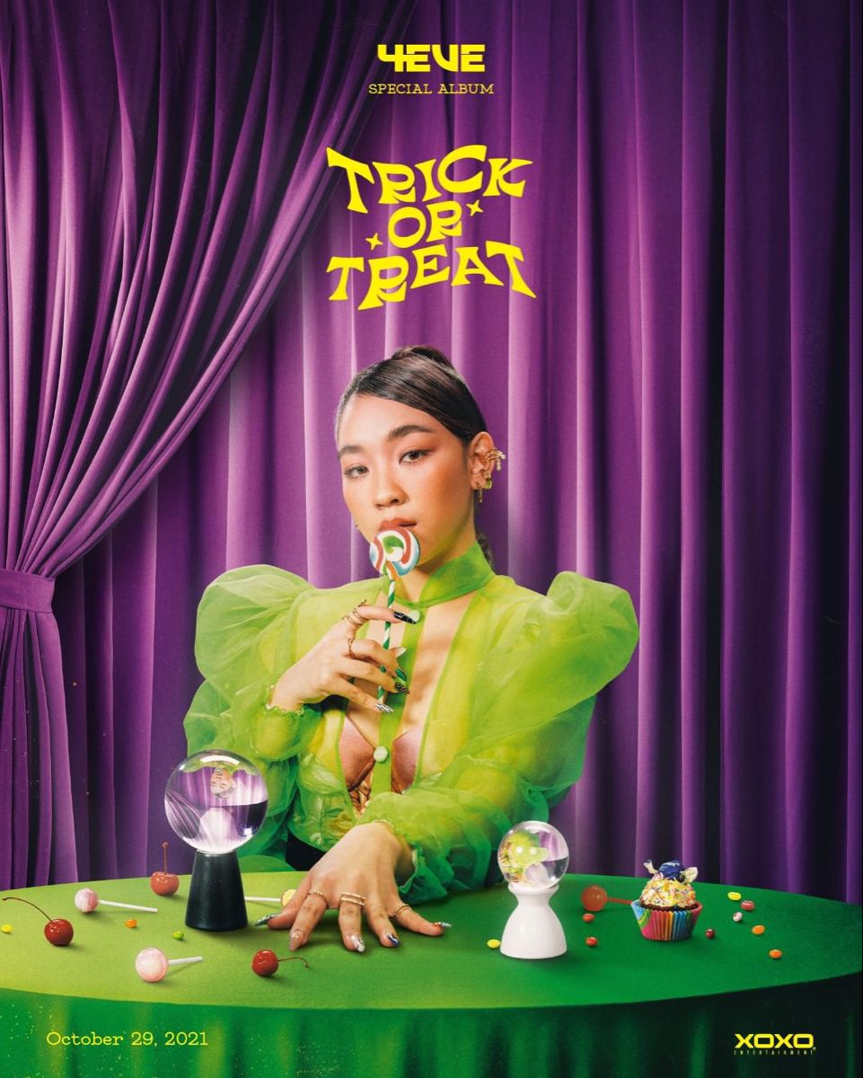Woman in sheer lime blouse holding a swirl lollipop at a green fortune-teller table