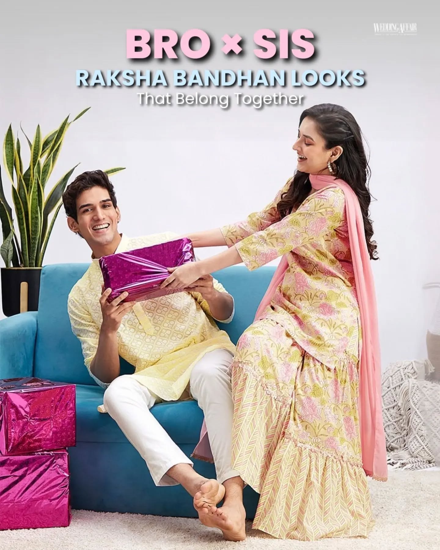 Brother and sister in coordinated pastel ethnic outfits playfully tugging a wrapped gift on a sofa