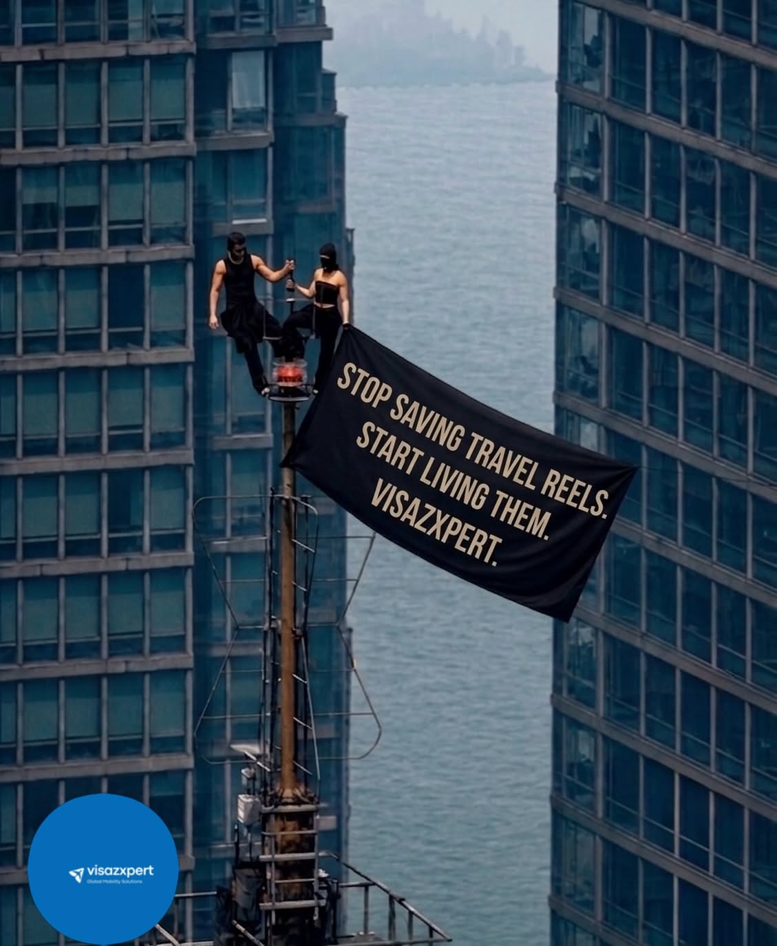 Instagram post: Masked couple on a skyscraper mast unfurling a black slogan banner