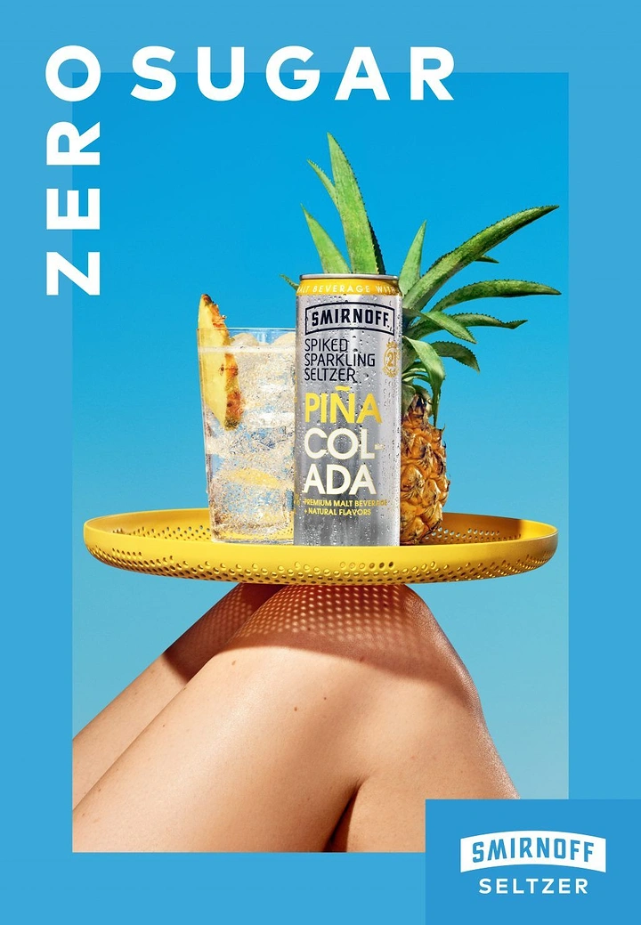 Beer, Wine & Spirits creative ad: Seltzer can, glass and pineapple on a yellow tray balanced on knees