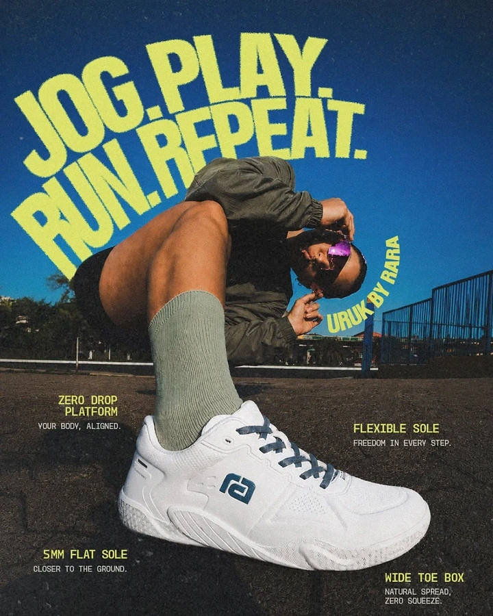 Streetwear creative ad: Crouching model in a white sneaker, shot from a low angle