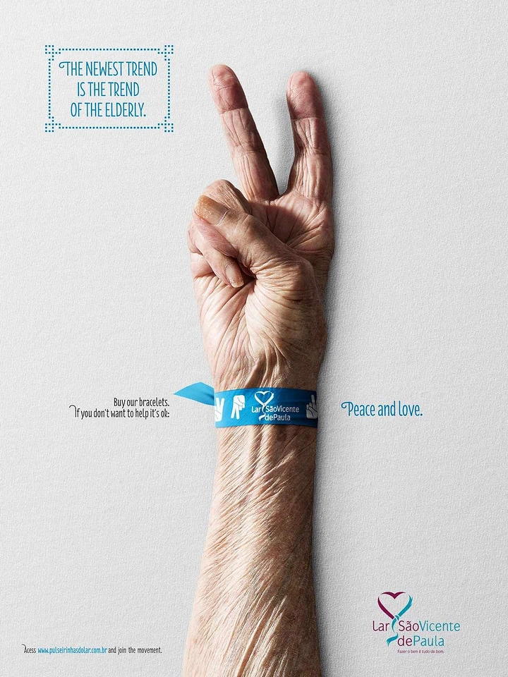 Senior Care creative ad: Elderly hand making a peace sign while wearing a blue charity wristband