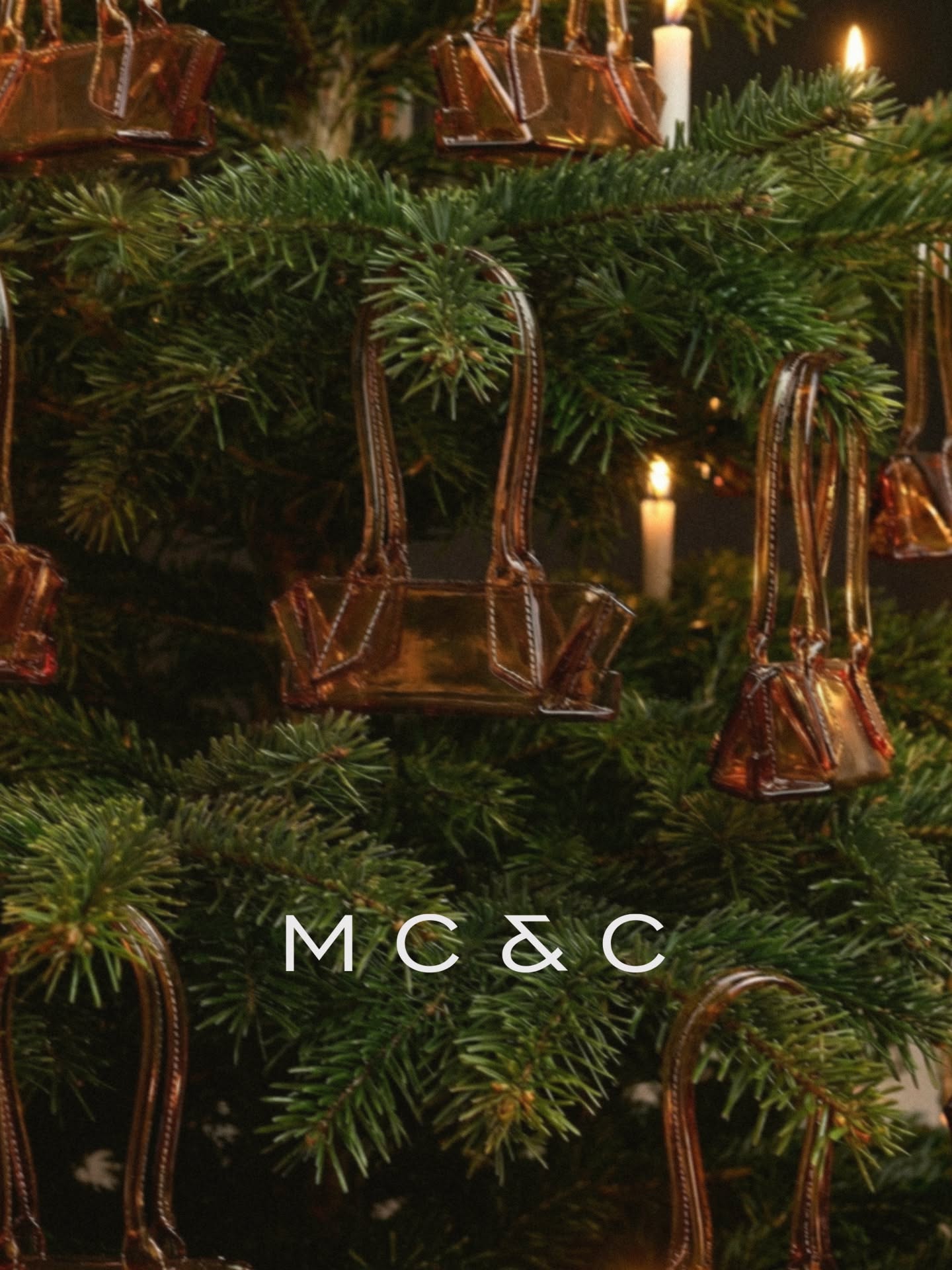 Christmas Instagram post: Amber glass handbag-shaped ornaments hanging on a candlelit fir tree