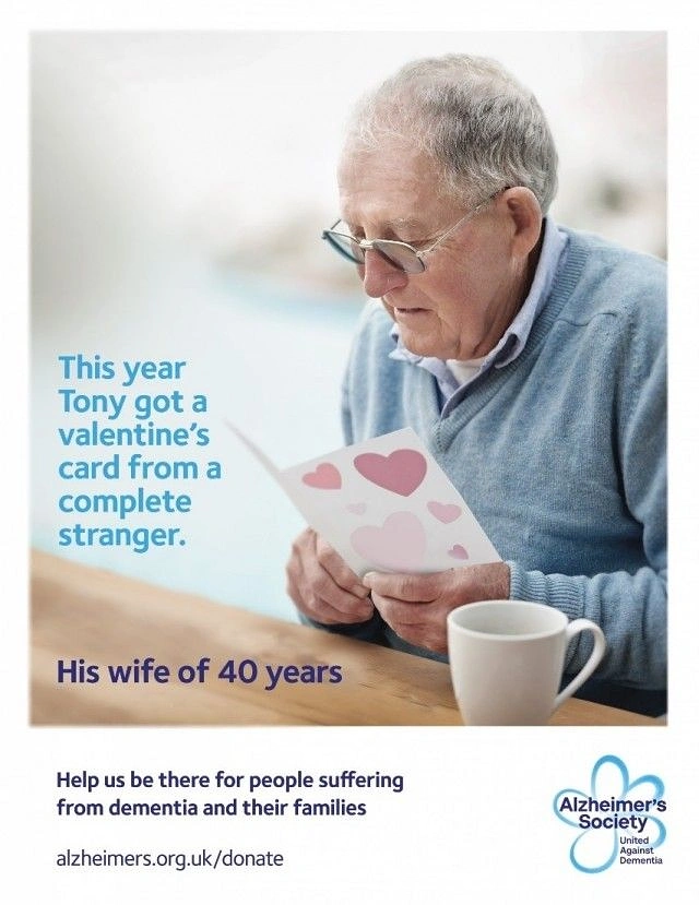 Valentine's Day creative ad: Elderly man reading a heart-covered valentine card at a table