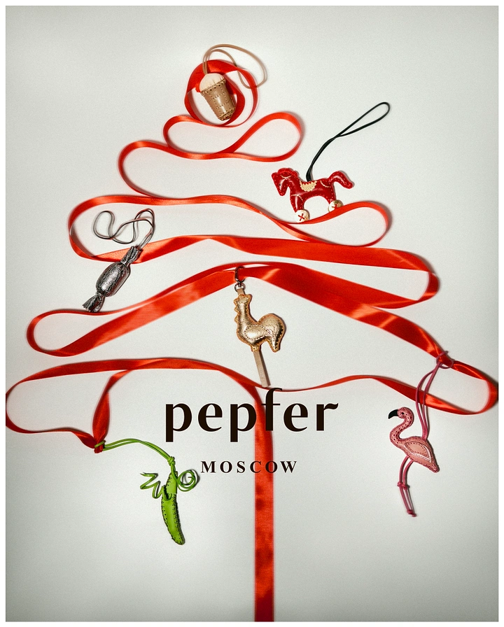 Christmas creative ad: Red satin ribbon shaped into a Christmas tree hung with leather charms