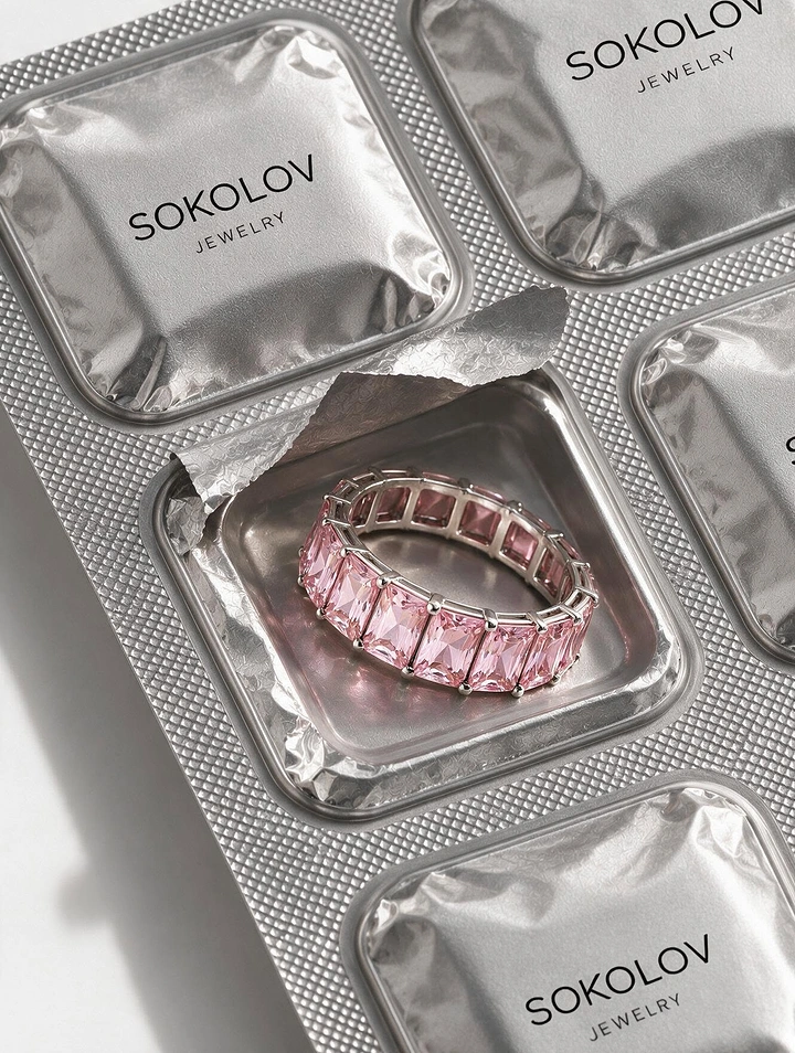 Jewellery creative ad: Pink emerald-cut eternity ring in an opened foil blister pack
