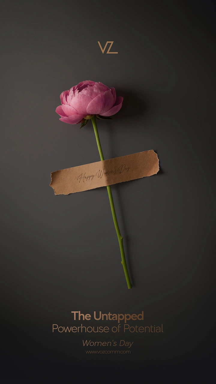 Women's Day creative ad: Single pink peony taped to a dark surface with kraft paper