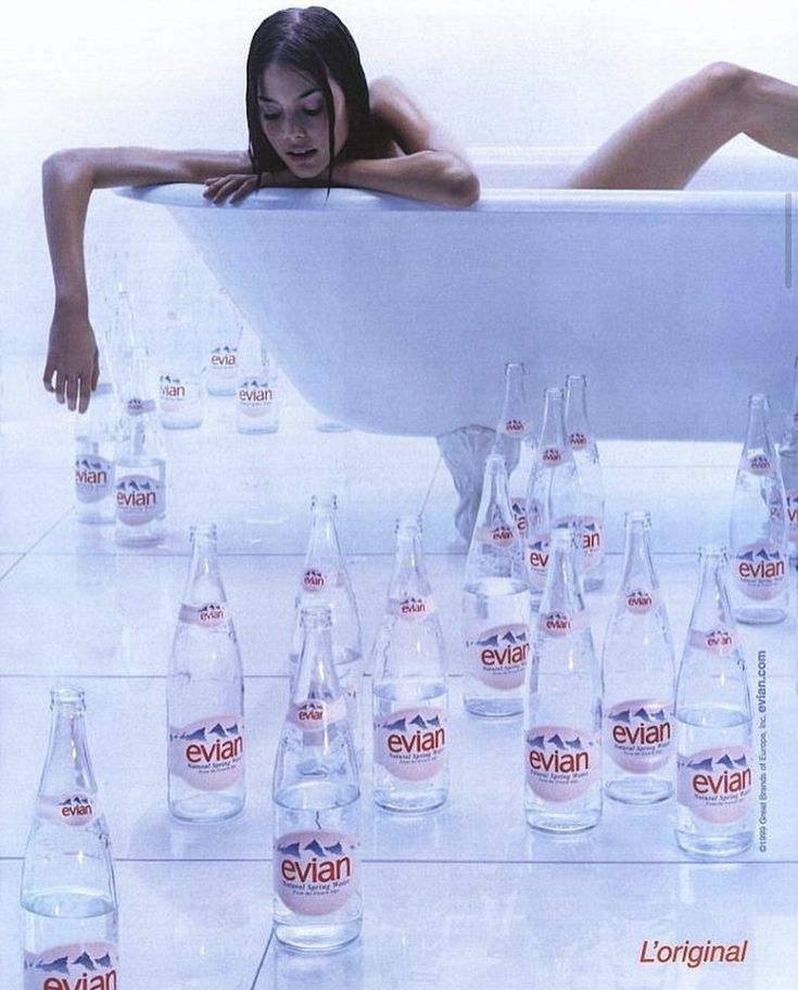 Poster: Woman leaning out of a bathtub over rows of glass water bottles