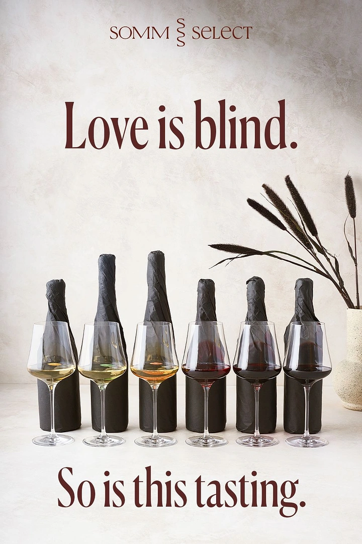 Valentine's Day creative ad: Six wine glasses from white to red in front of black-paper-wrapped bottles