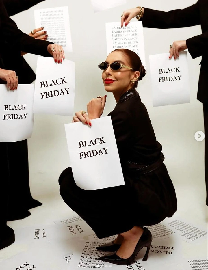 Black Friday creative ad: Crouching woman in black holding a Black Friday sign