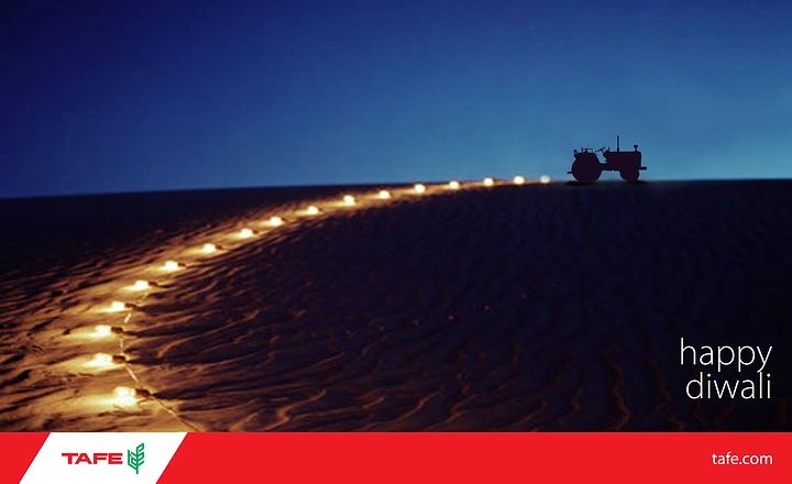 Diwali creative ad: Line of glowing lamps leading up a dune to a tractor silhouette