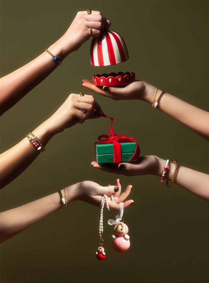 Christmas creative ad: Hands reaching in to open and hold festive gift boxes and jewellery