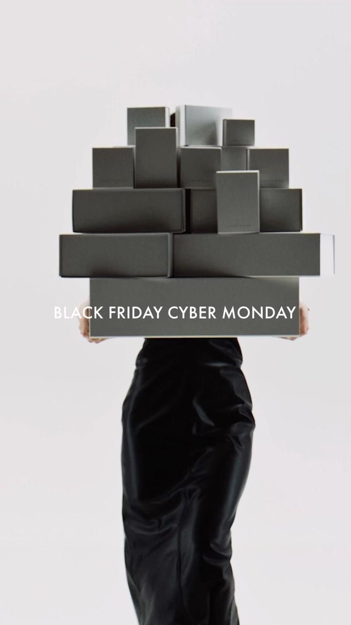 Model carrying a tall pyramid of grey boxes that hides her upper body