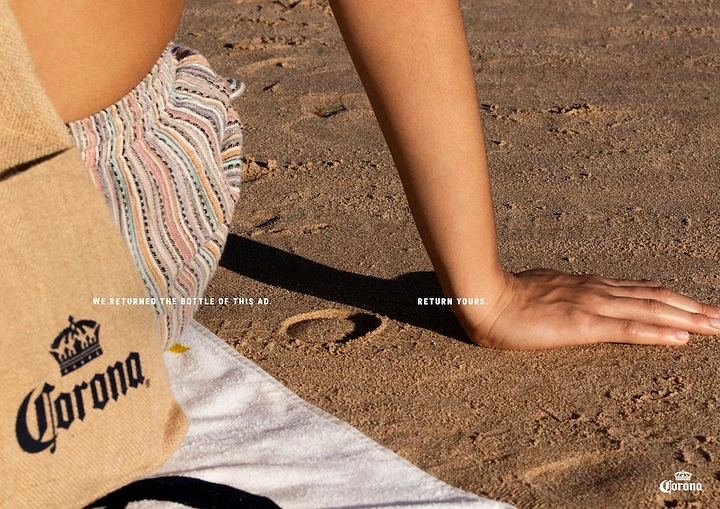 Beer, Wine & Spirits creative ad: Circular bottle-base imprint in beach sand beside a sunbather's hand