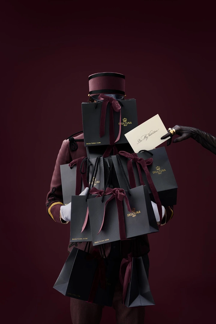 Valentine's Day creative ad: Bellhop buried under a stack of branded gift bags