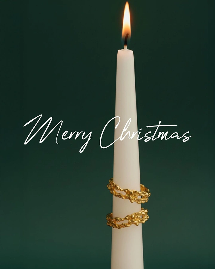 Christmas creative ad: Lit white taper candle wrapped with gold organic rings