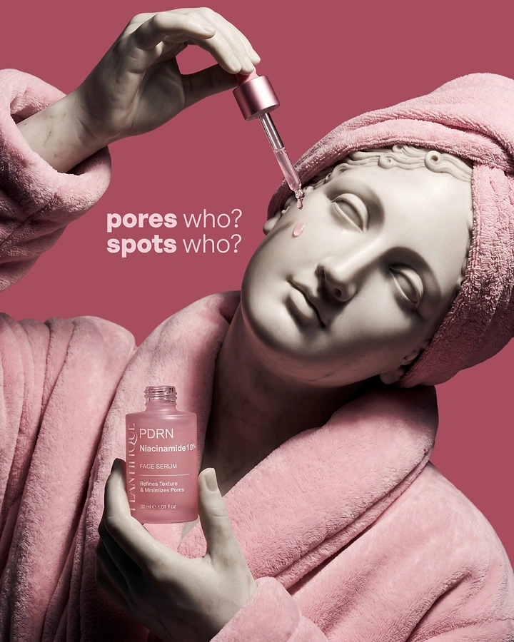 Skincare & Cosmetics creative ad: Classical marble statue in a pink bathrobe and towel turban applying serum with a dropper