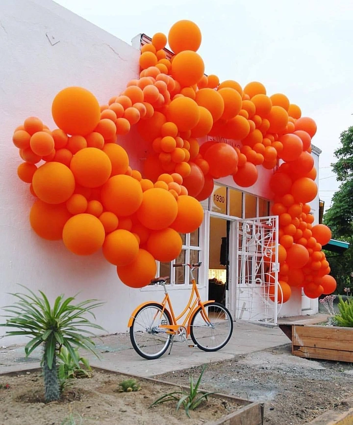 Balloon & Party Decorators creative ad: Massive orange balloon cloud framing a white storefront