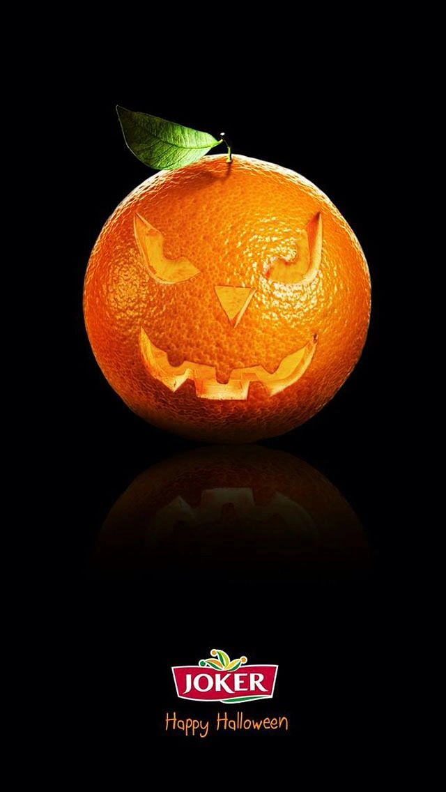 Halloween creative ad: Orange carved like a jack-o'-lantern with a leaf