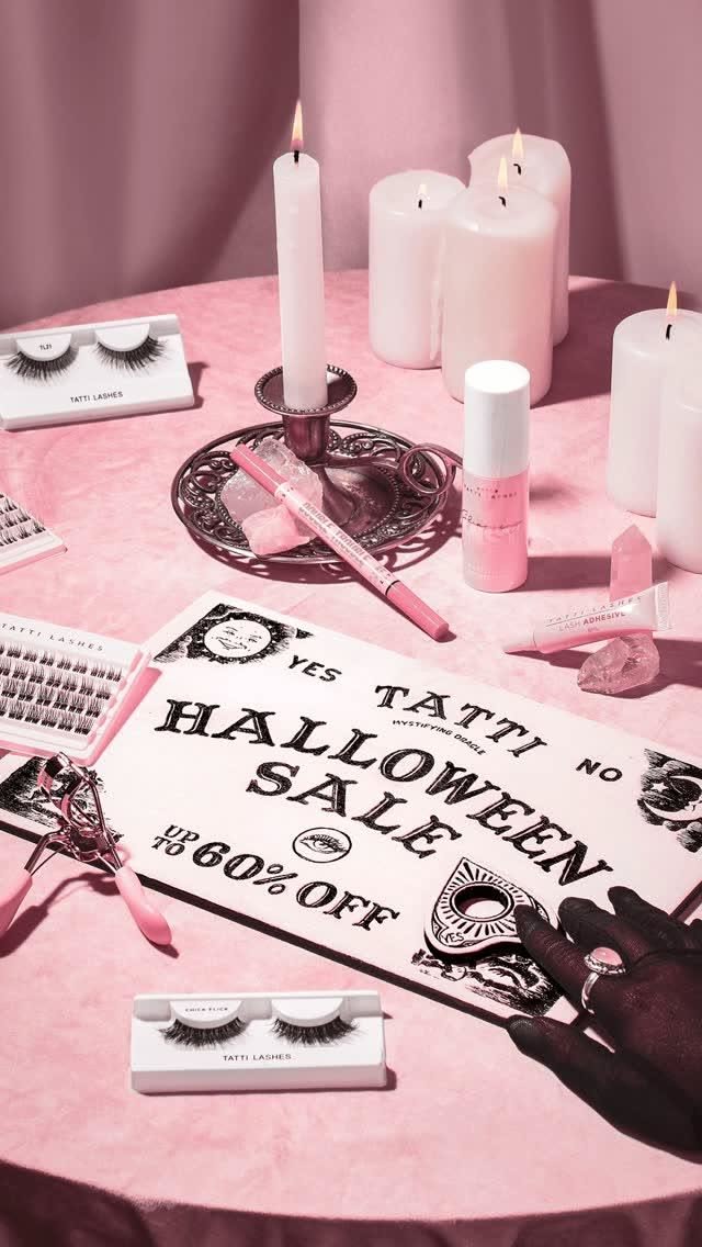 Halloween Story: Pink séance table with a Ouija-board sale sign surrounded by lash products