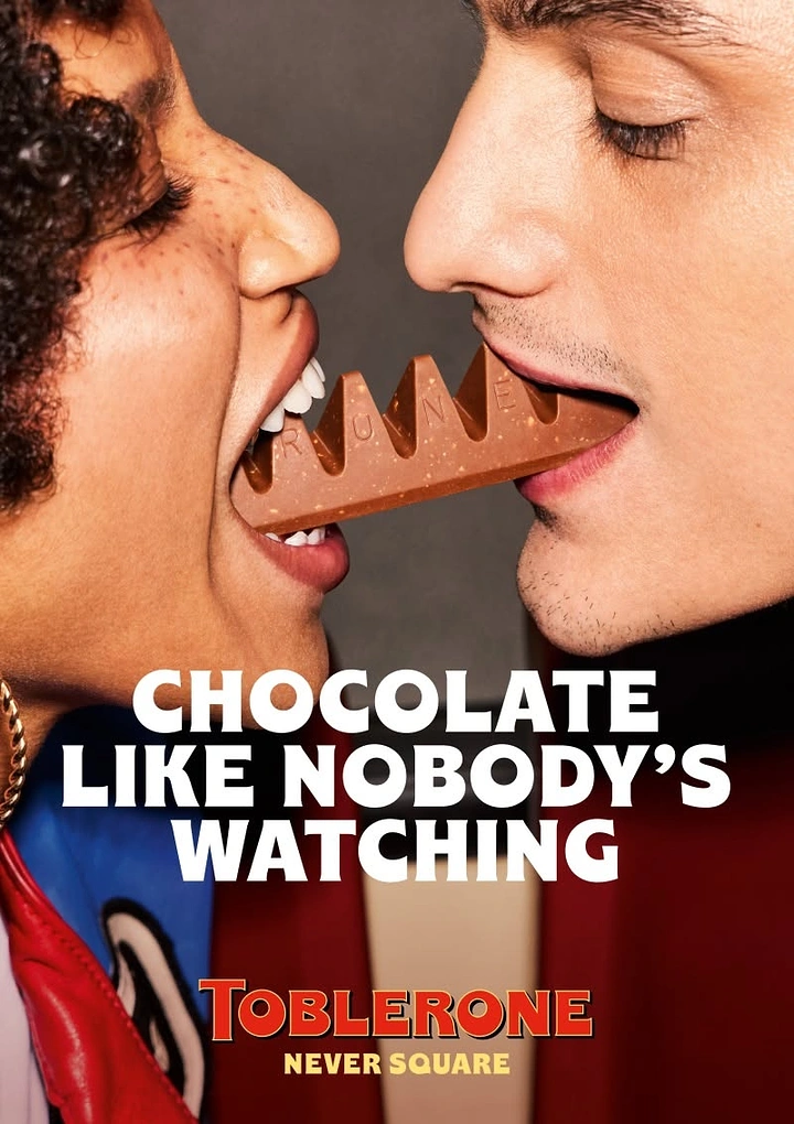 Sweet Shop creative ad: Two people biting opposite ends of a triangular chocolate bar