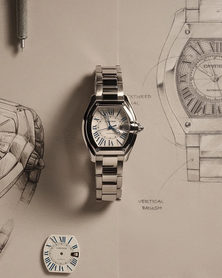 Creative ad: Steel watch laid flat on hand-drawn design sketches
