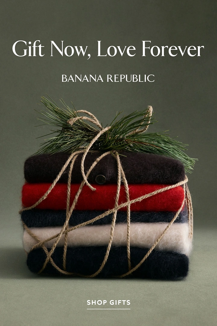 Christmas creative ad: Stack of folded knit sweaters tied with twine and pine sprig