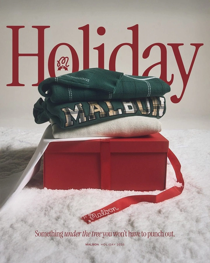 Christmas creative ad: Stack of folded knit sweaters on a red gift box in snow