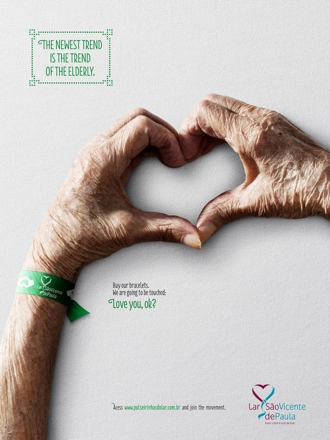 Senior Care creative ad: Wrinkled elderly hands forming a heart, wearing a green charity wristband