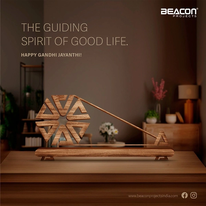 Gandhi Jayanti creative ad: Stylised wooden charkha sculpture on a tabletop
