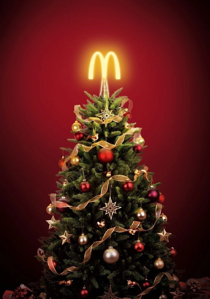 Christmas creative ad: Decorated Christmas tree topped with a glowing logo