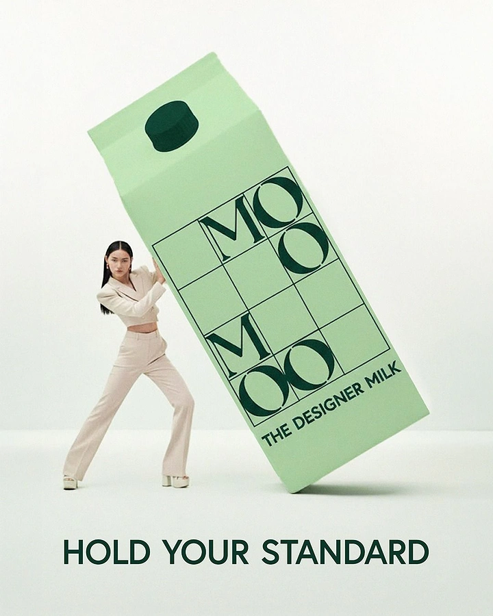 Fashion creative ad: Fashion model propping up a giant tilted mint-green milk carton