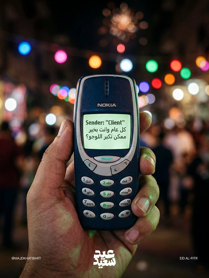 Eid creative ad: Hand holding a classic Nokia phone showing an Eid text message