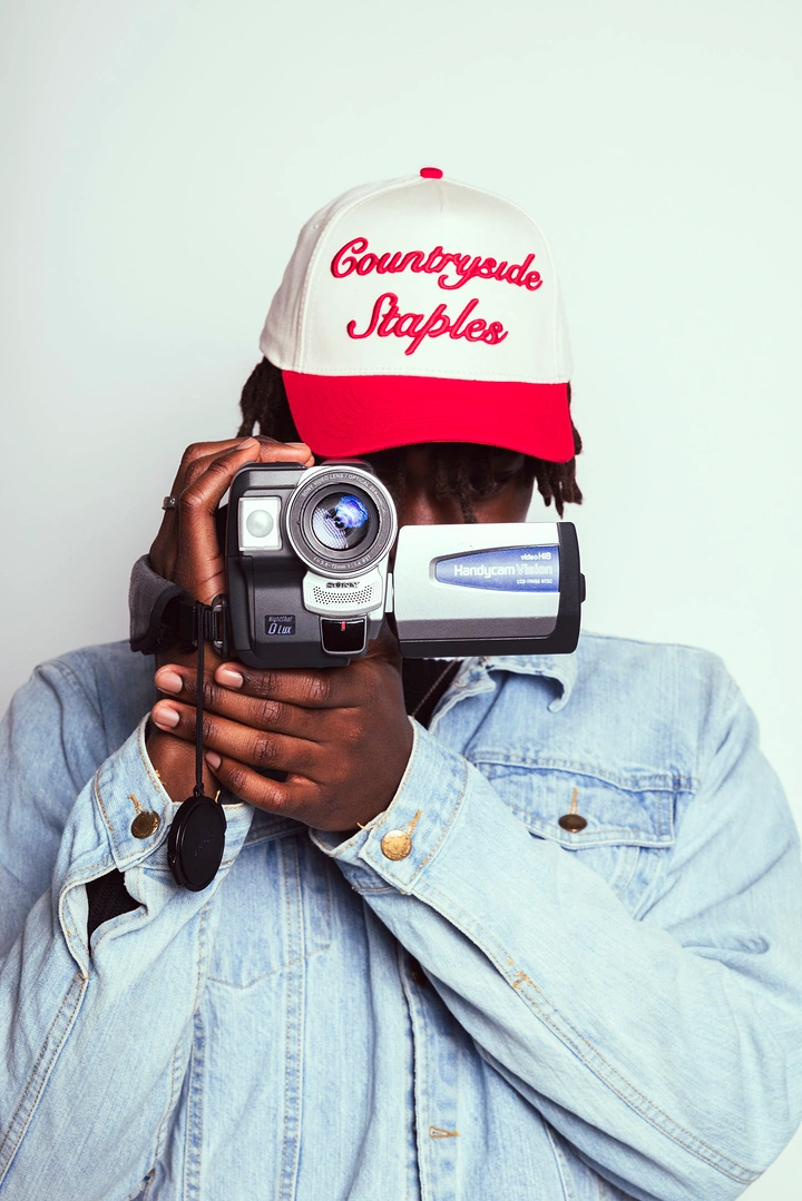 Hats & Caps creative ad: Camcorder portrait turns cap into prop
