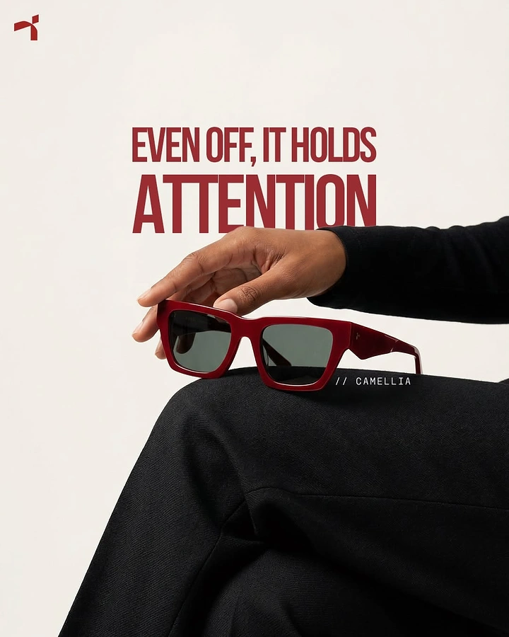 Creative ad: Hand resting red acetate sunglasses on a knee in black trousers