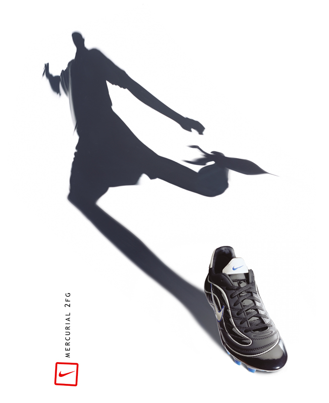 Football boot casting the shadow of a player mid-kick