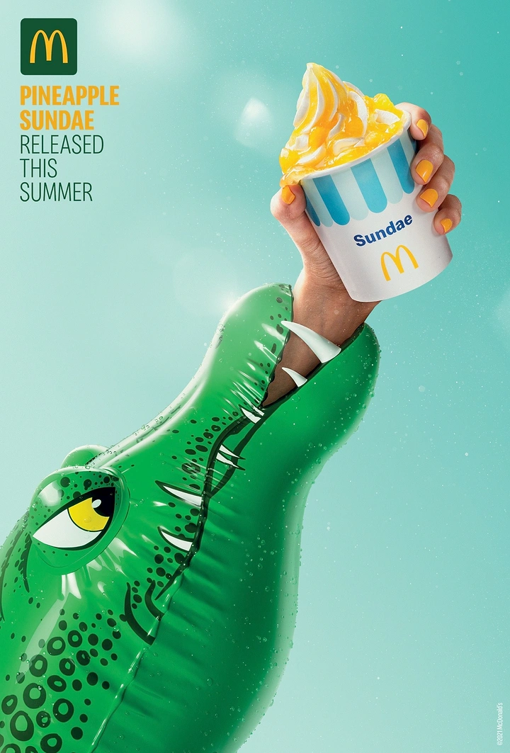 Fast Food creative ad: Hand emerging from inflatable crocodile's mouth holding a pineapple sundae