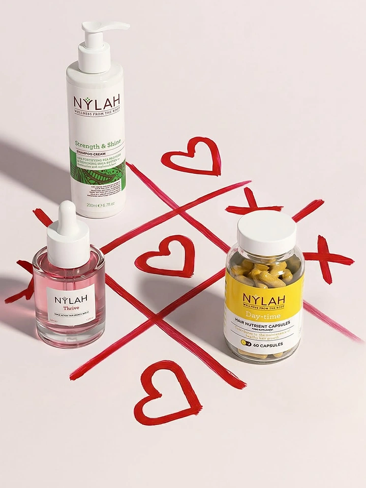 Valentine's Day creative ad: Haircare products on a tic-tac-toe grid of red painted hearts and X's