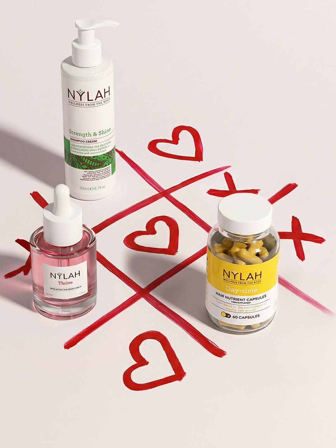 Haircare products on a tic-tac-toe grid of red painted hearts and X's