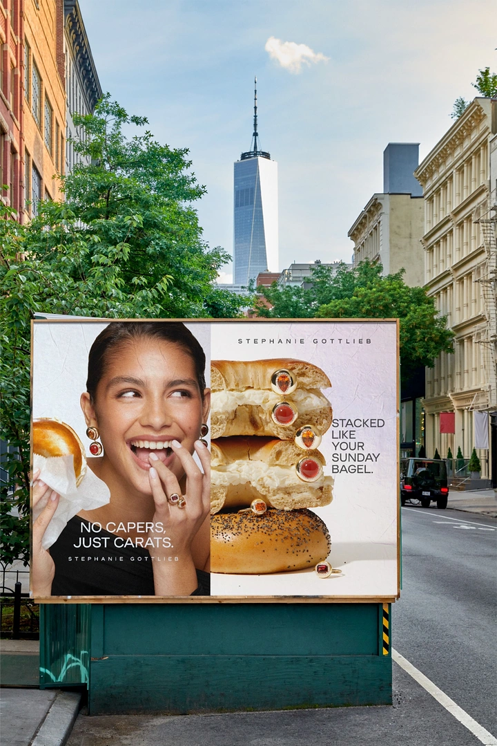 Jewellery creative ad: Model biting a bagel beside a bagel stack studded with gem rings