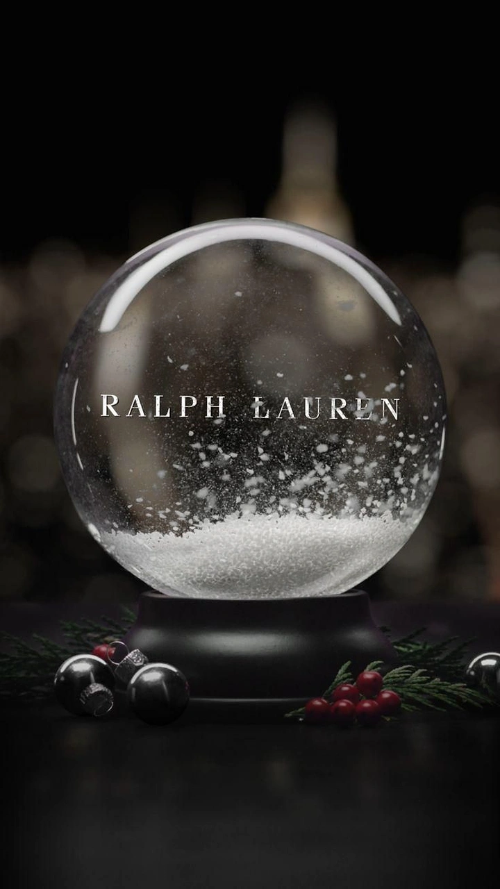 Christmas creative ad: Snow globe with falling snow on a dark tabletop