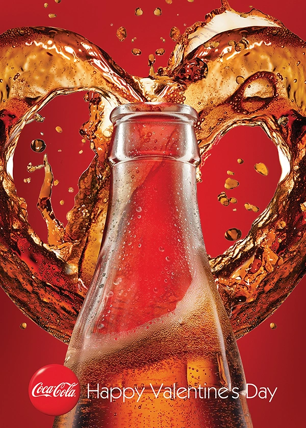 Valentine's Day creative ad: Cola splash forming a heart behind a glass bottle neck