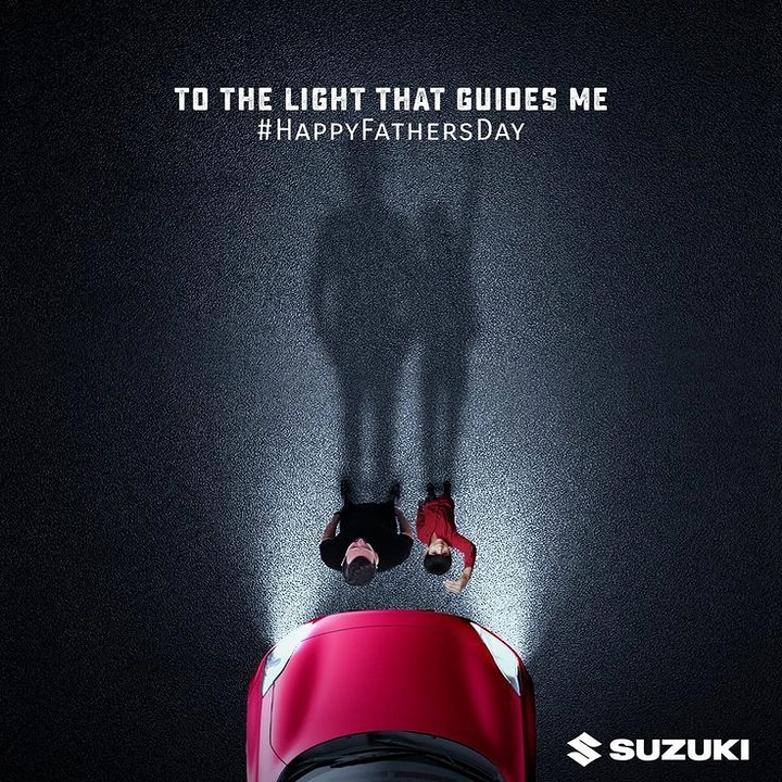 Father's Day creative ad: Top-down red car headlights lighting a father and child on dark road